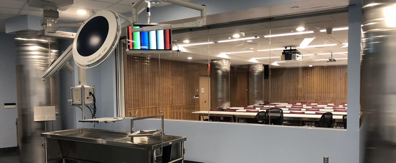 NYU Langone Health Smilow Research Center, Cadaveric Skills Lab, interior with autopsy table in the foreground and classroom in the background<br />
