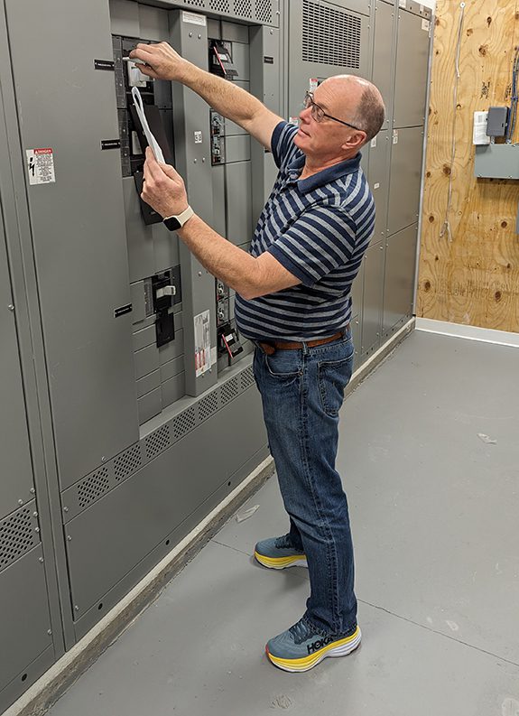 An electrical engineer checking breaker settings against a study.
